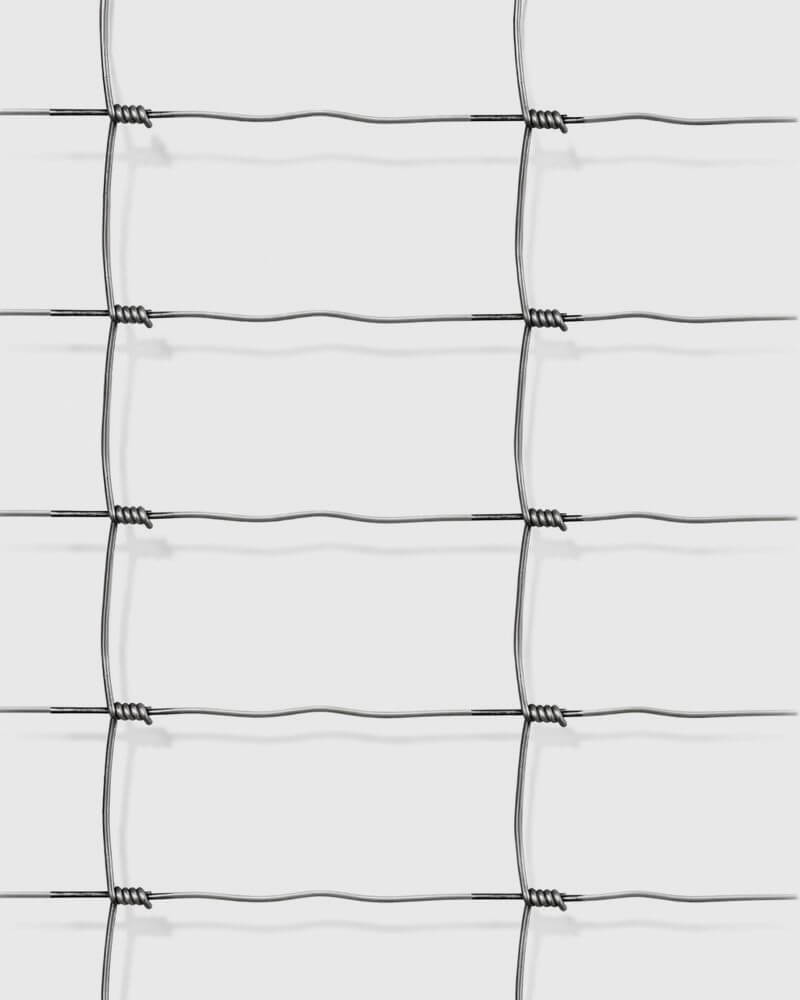 Verzinkt schapengaas met rechthoekige mazen, strak en gelijkmatig raster, gefotografeerd tegen een grijze achtergrond.